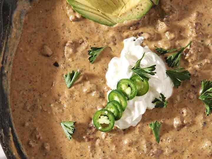 Close up of the homemade queso in a skillet with its garnishes