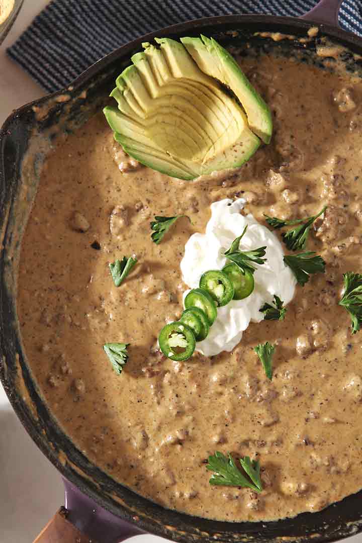 Close up of the homemade queso in a skillet with its garnishes