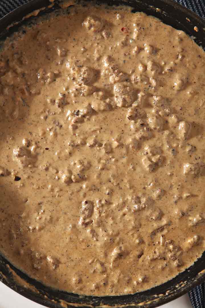 Close up of ground beef mixed into queso