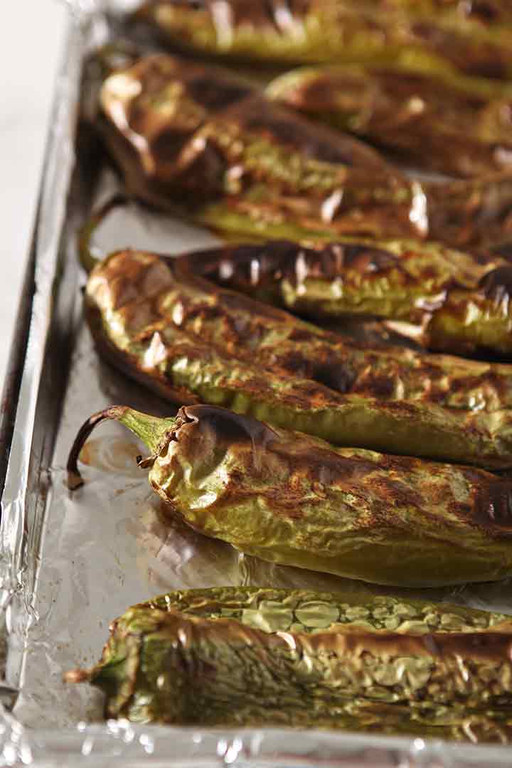 Roasted Hatch chiles line a baking dish, close up