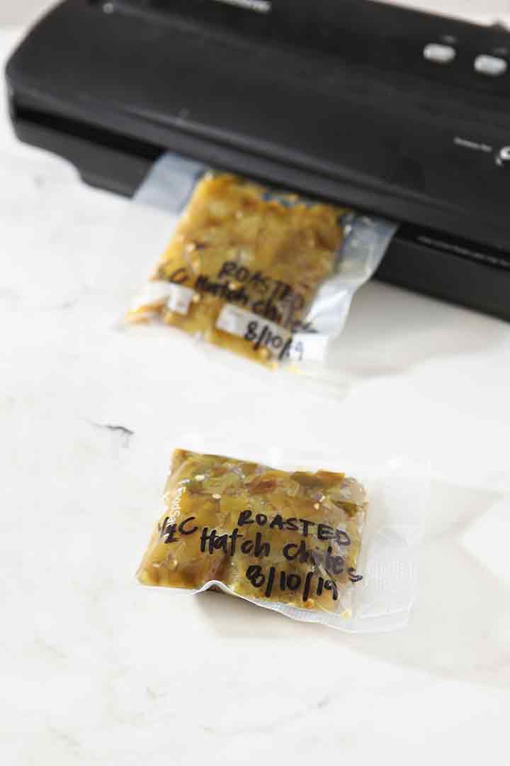 A vacuum sealer is used to seal baggies of roasted, chopped peppers for the freezer