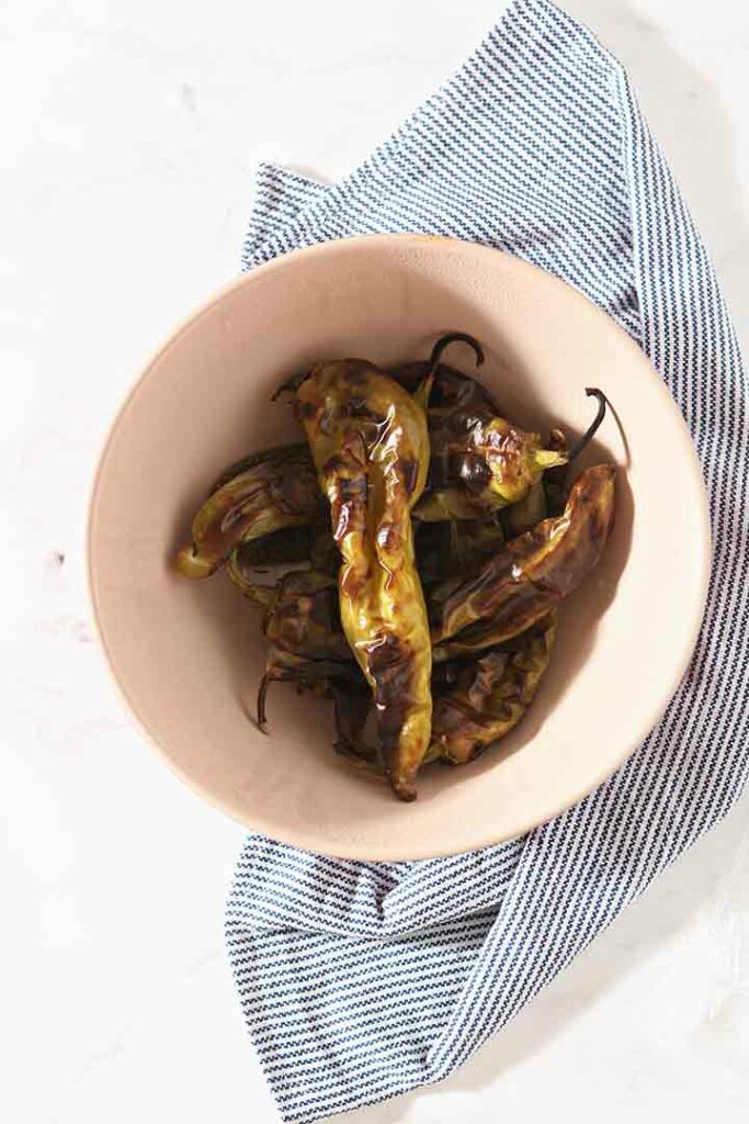 Roasted peppers are shown in a bowl, from above