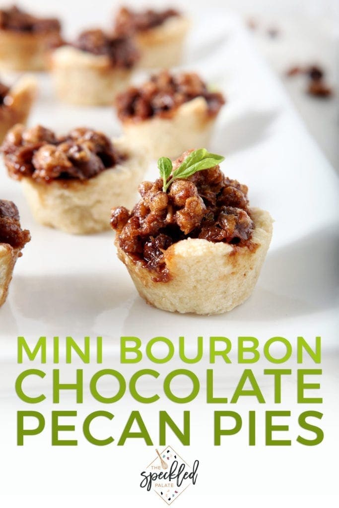 Several Mini Bourbon Chocolate Pecan Pies sit on a white platter, ready for serving