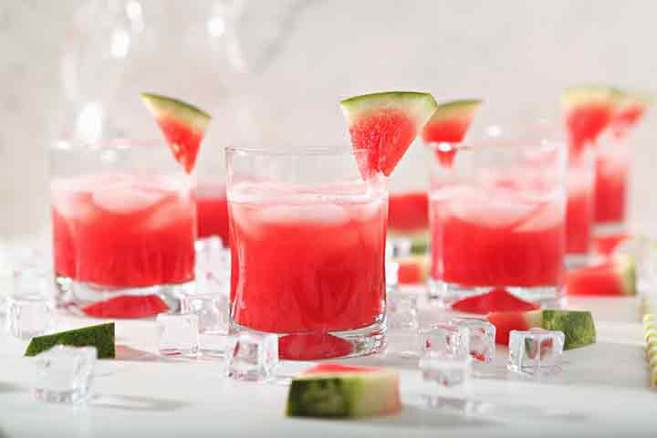 Several glasses of Watermelon Agua Fresca are garnished with watermelon wedges before drinking