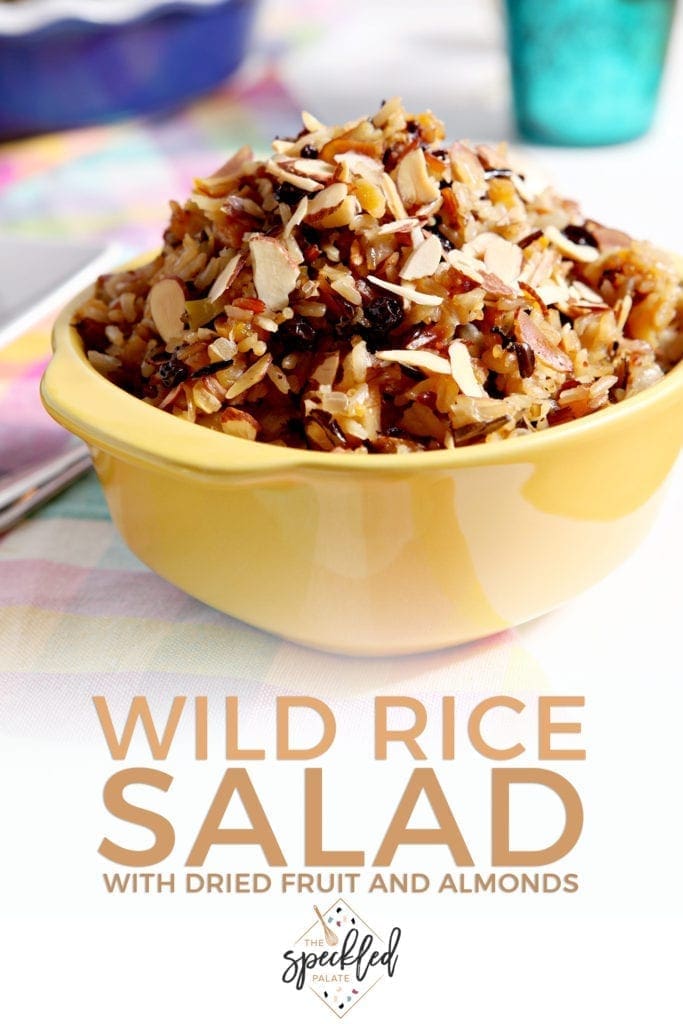 A container of Wild Rice Salad sits on a tabletop, with Pinterest text