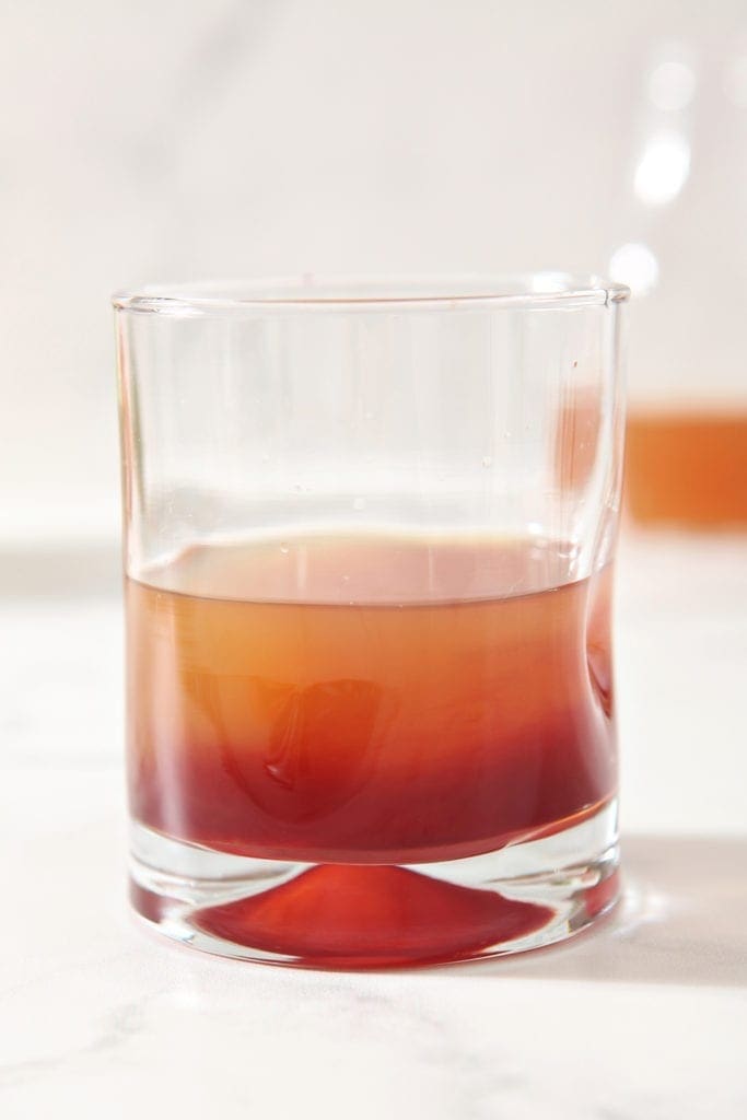 Close up of a glass of Apple Cider Punch that hasn't been stirred or garnished