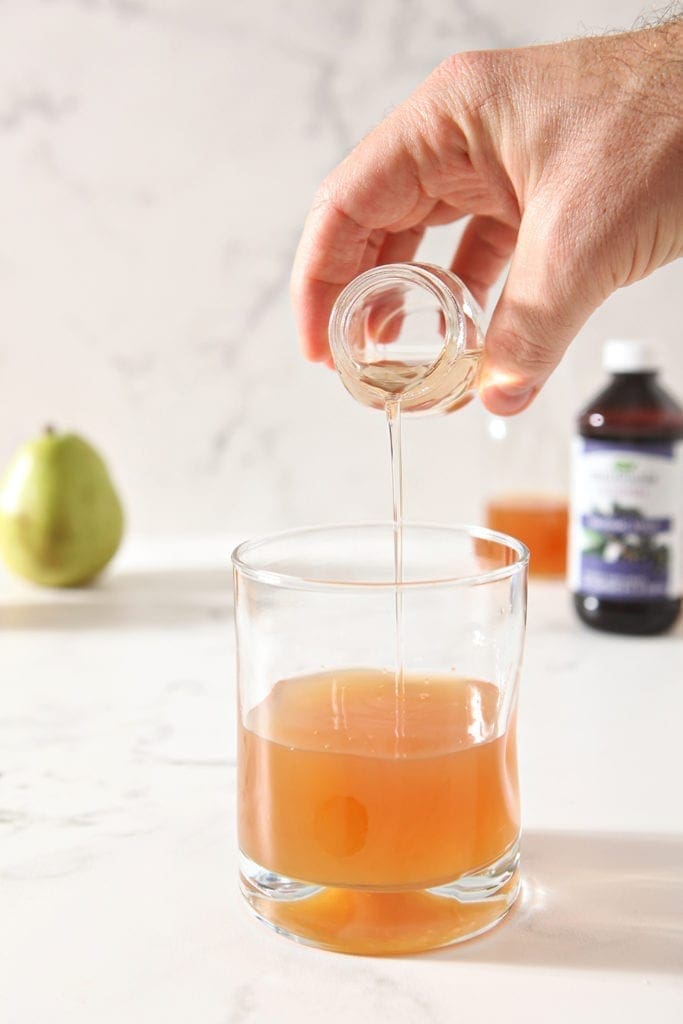 Cinnamon simple syrup is poured into the punch glass