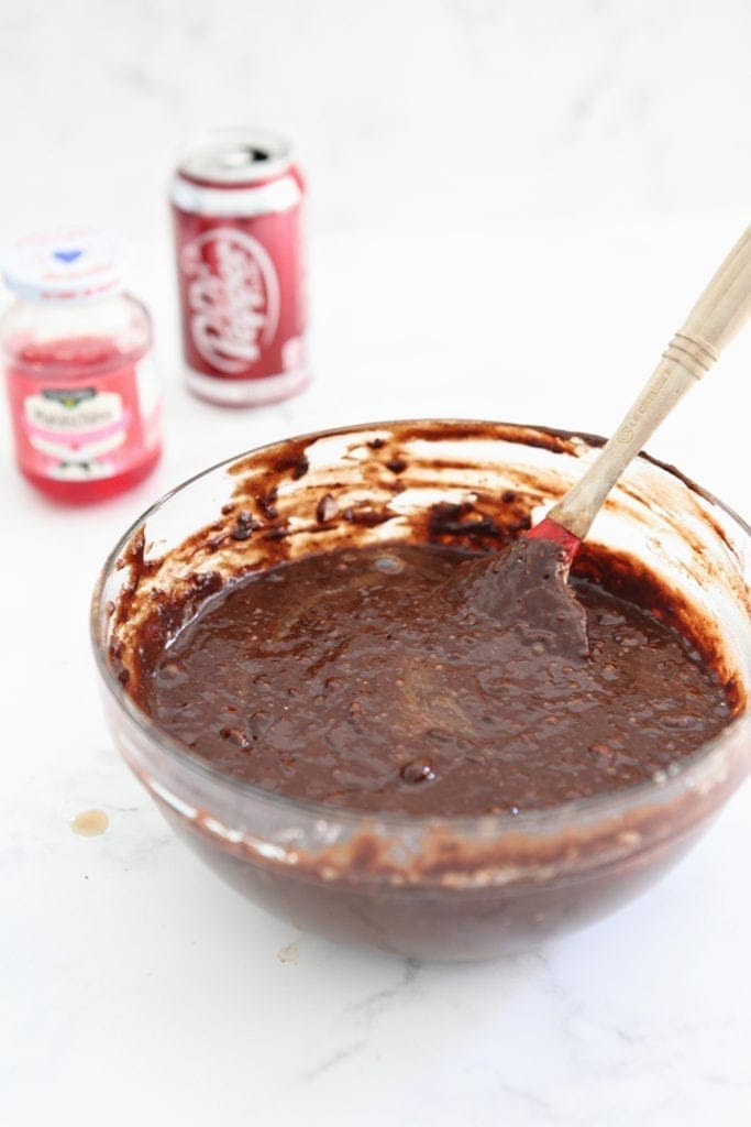 Brownie batter in a bowl, with maraschino cherries and Dr Pepper in the background