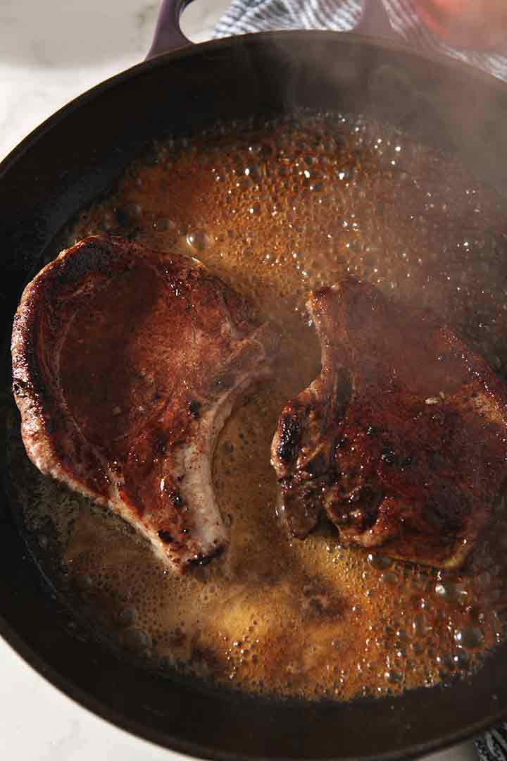 Wine cooks down in the skillet with the pork chops