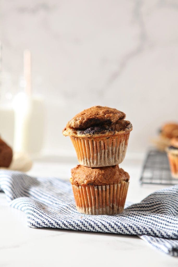 Pumpkin Muffins are stacked on top of each other, shown with glasses of milk