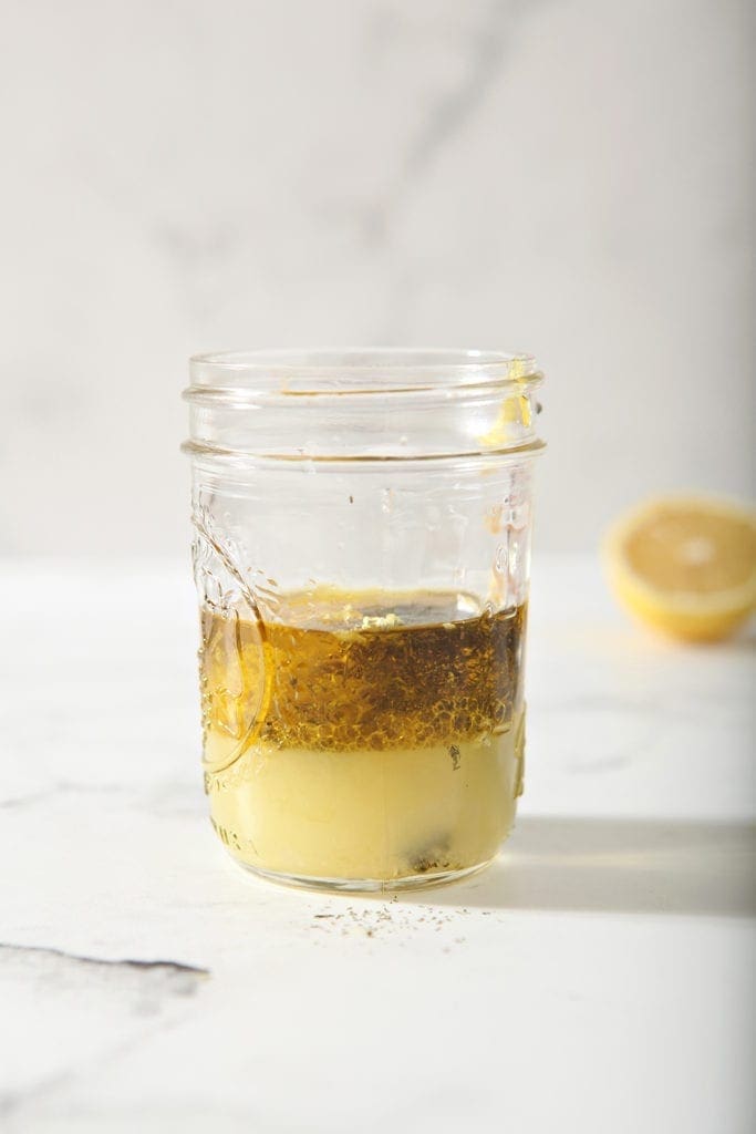 The Lemon Vinaigrette is shown, unmixed, on a marble background