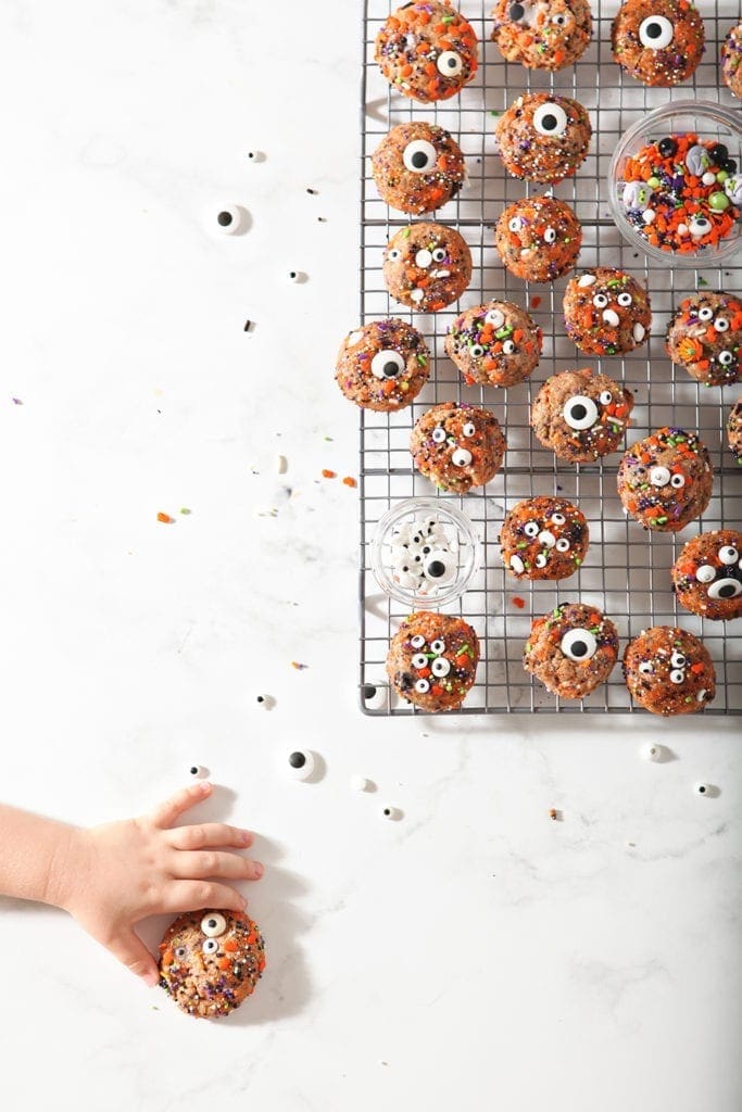 A girl reaches out to grab a Halloween Funfetti Cookie, from above