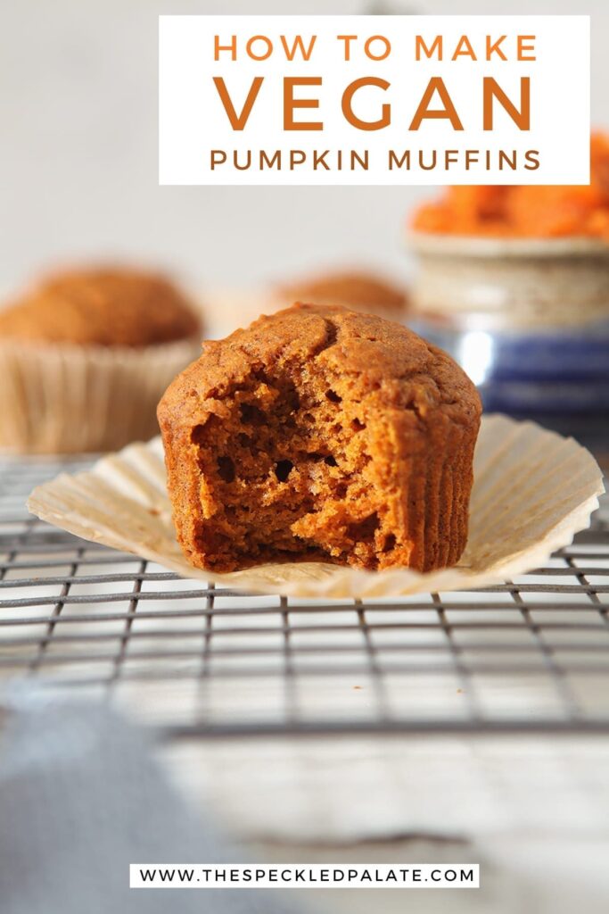 An orange muffin with a bite taken out of it on a wire rack with the text 'how to make vegan pumpkin muffins'