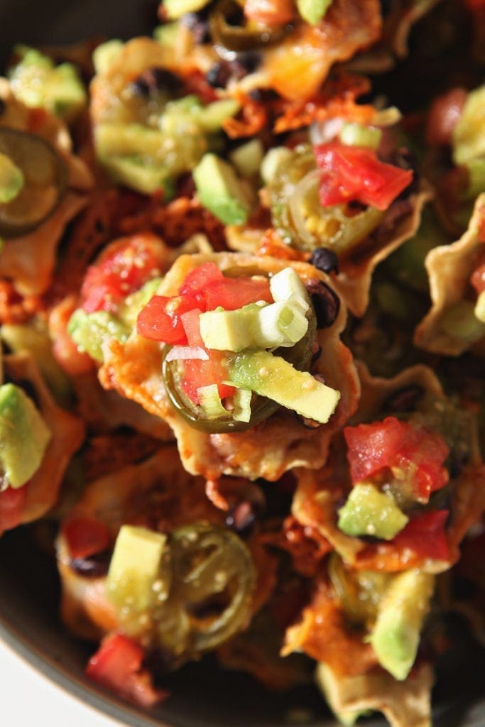 The garnished individual loaded nachos are shown from above, close up