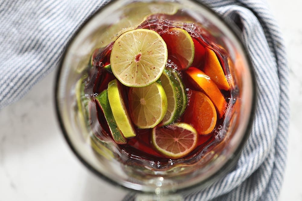 Overhead of citrus and cranberries in a pitcher