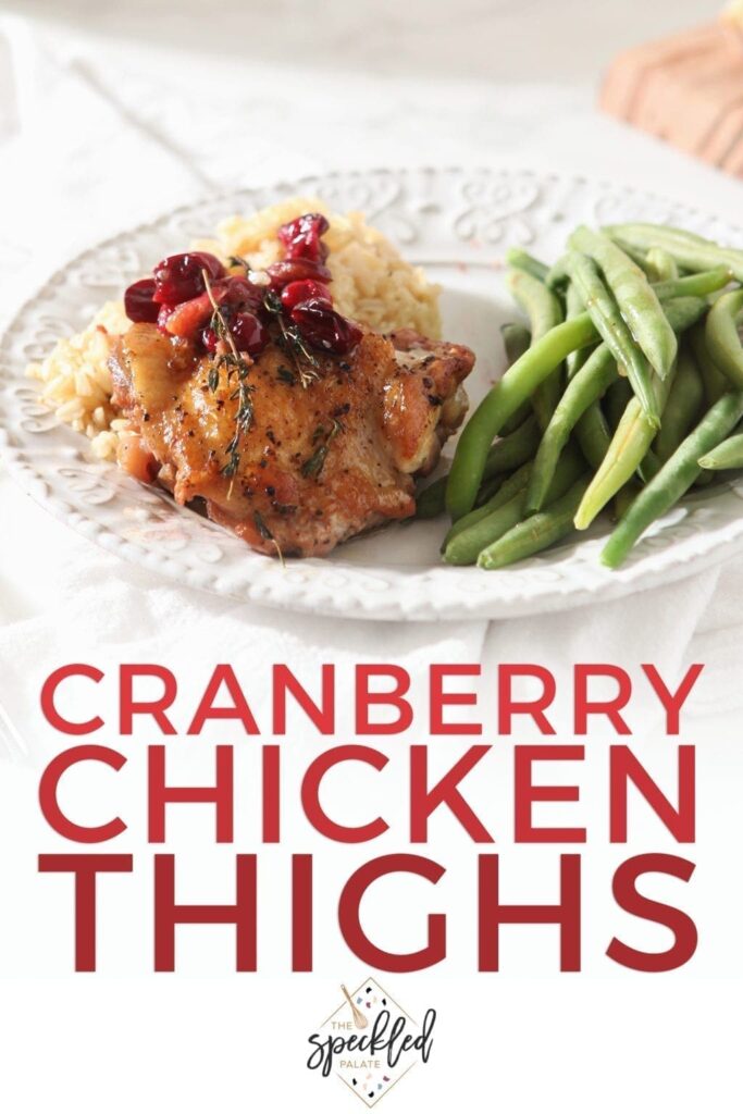 Cranberry chicken thigh on a plate with sides, with Pinterest text