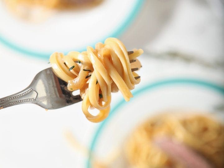 Pasta on a fork, above dishes
