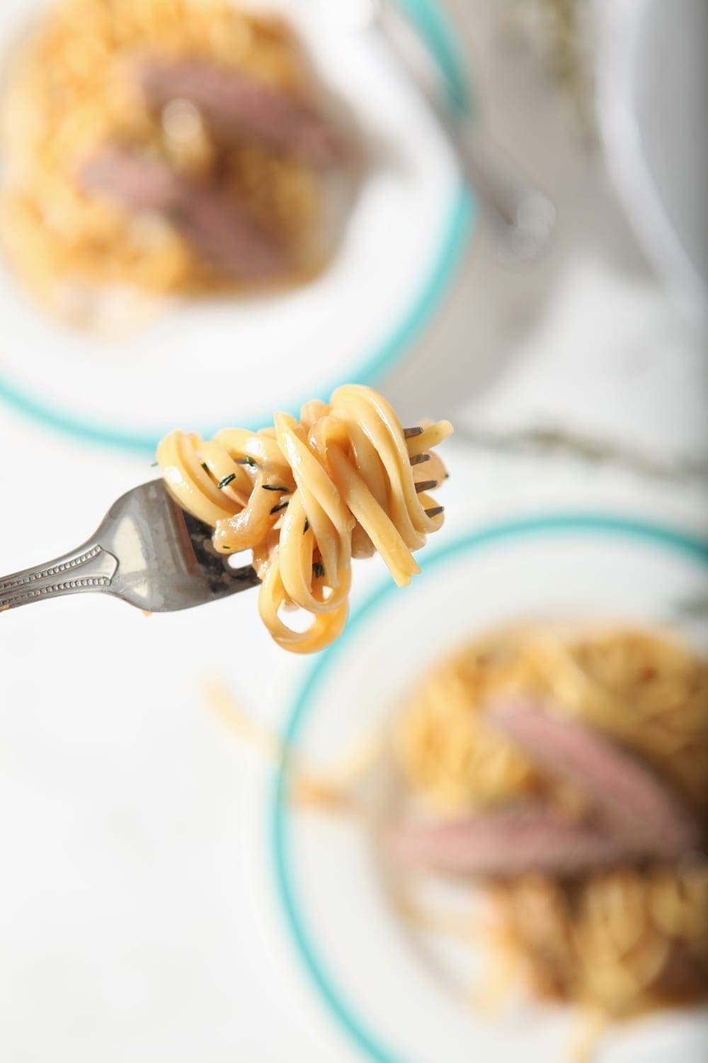 Pasta on a fork, above dishes