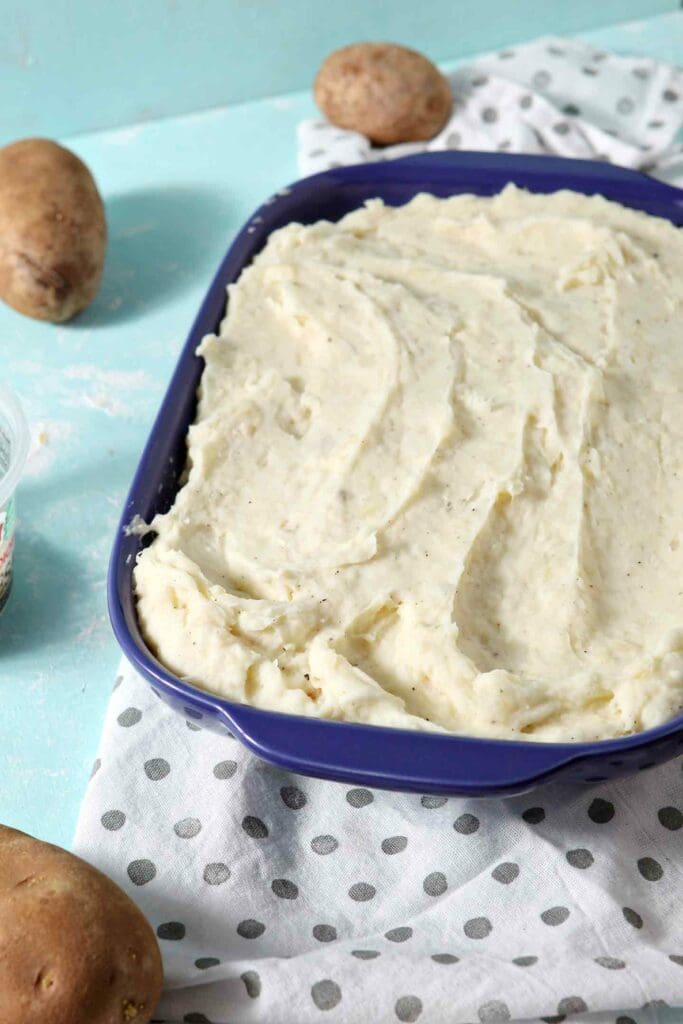 Garlic Parmesan Mashed Potato Casserole is topped with additional parmesan cheese before baking