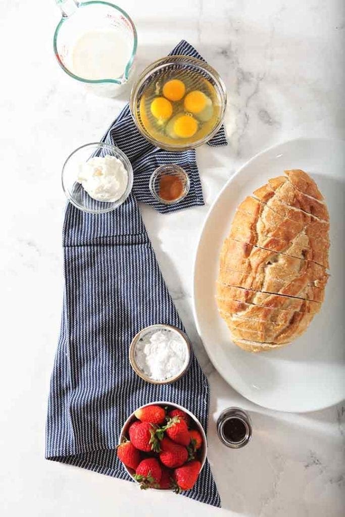 Ingredients for the french toast recipe, shown from above on top of a blue and white striped towel