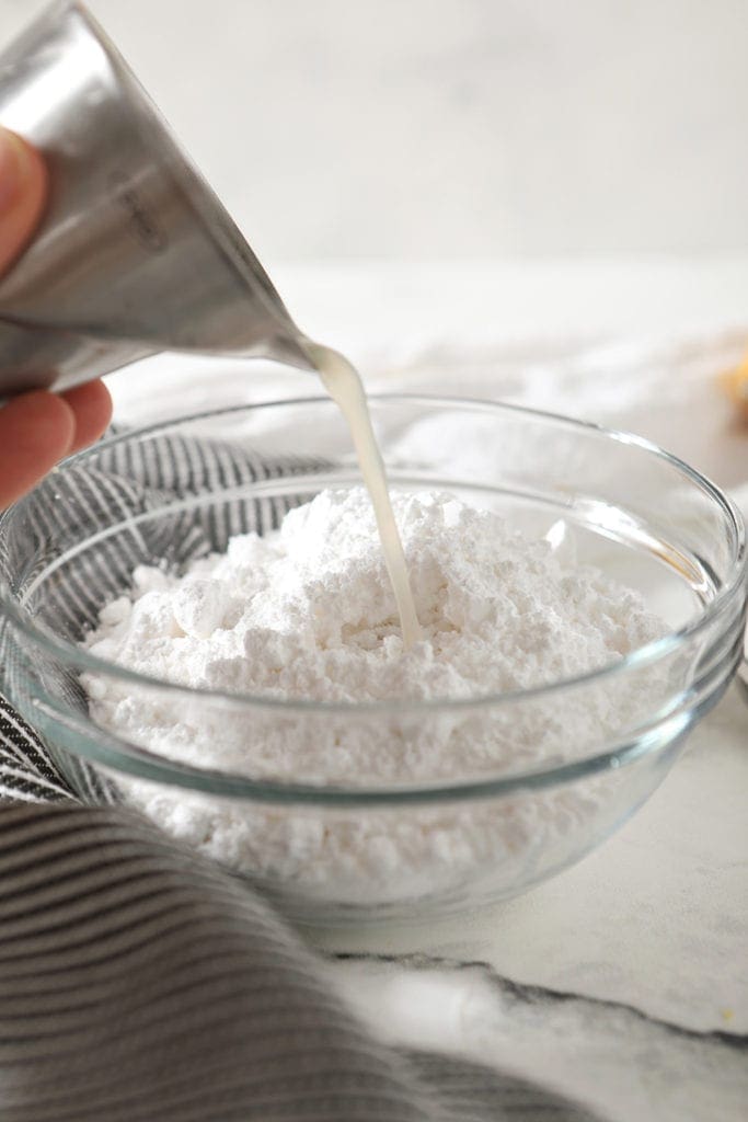 Lemon juice is poured on top of powdered sugar