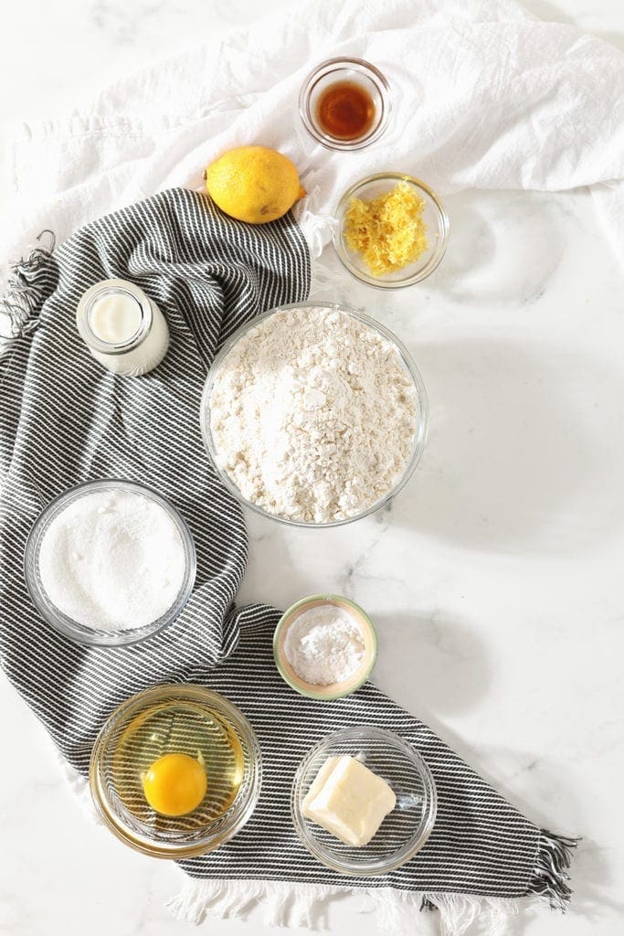 Ingredients for the soft lemon cookies are measured out in bowls, shown from above on top of a blue striped towel