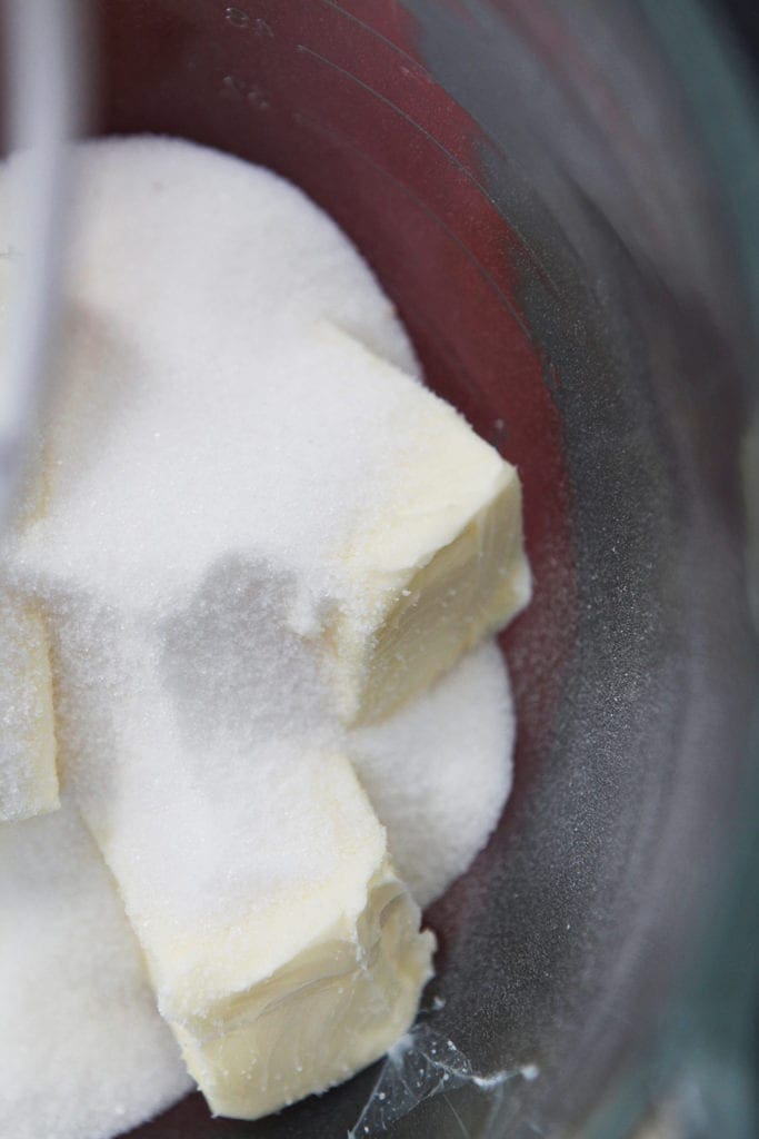 Sugar and butter are shown in a bowl of a stand mixer, before mixing