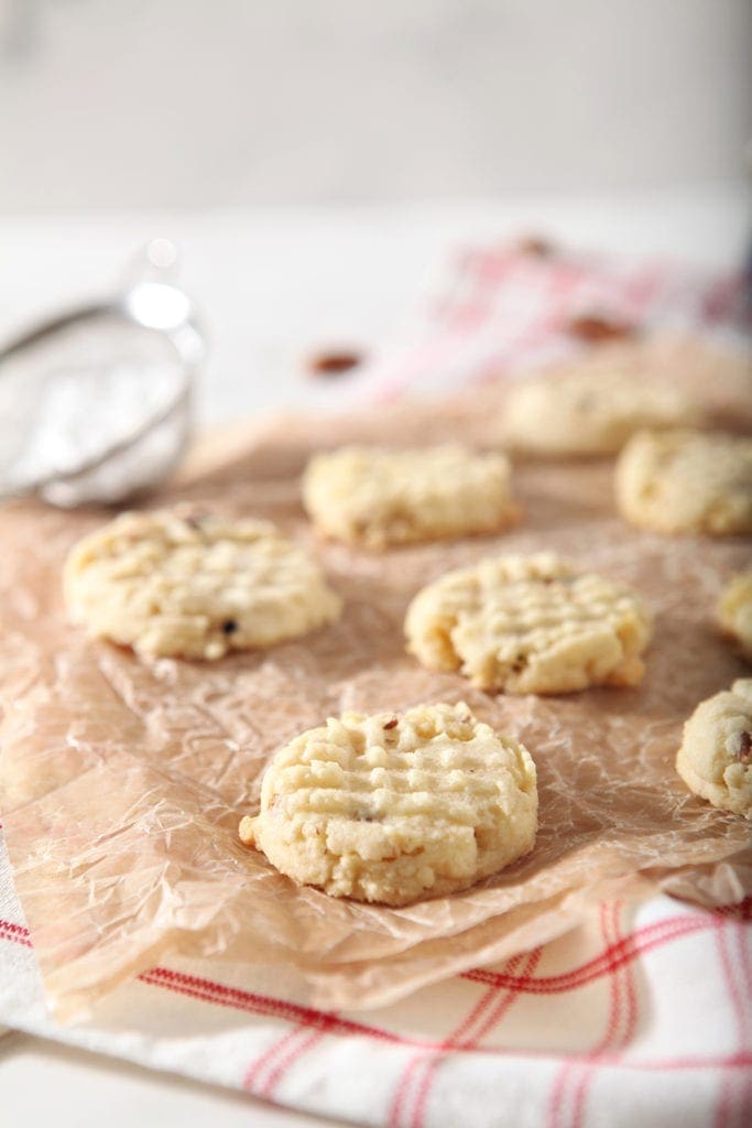 Potato Chip Cookies cool on a piece of parchment paper, before they're sprinkled with powdered sugar