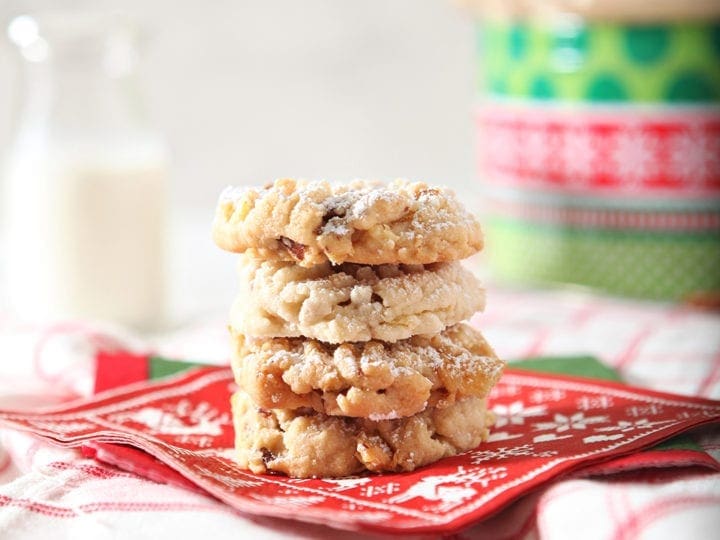 Three Potato Chip Cookies stacked on top of each other, served on a red napkin with milk in background