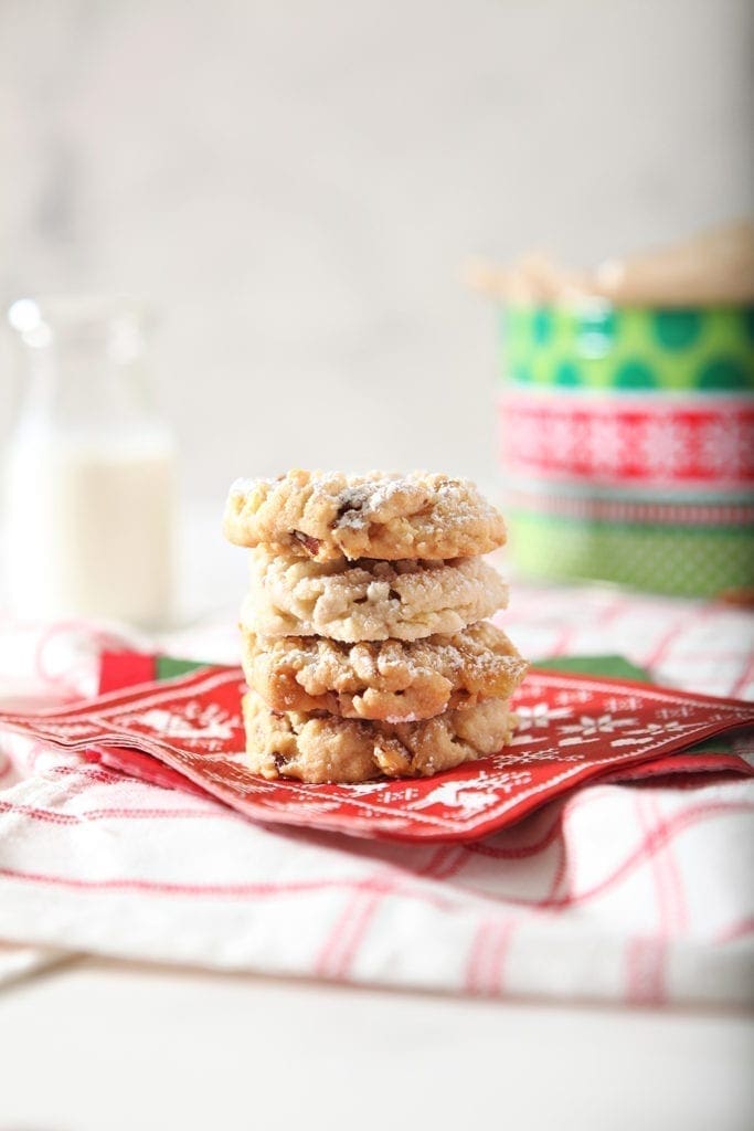 Three Potato Chip Cookies stacked on top of each other, served on a red napkin with milk in background