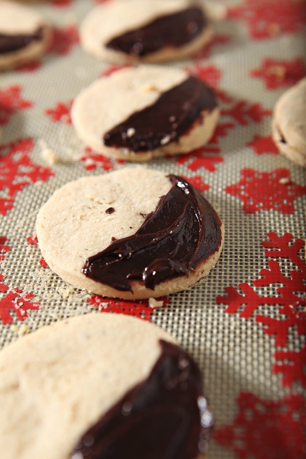 Shortbread cookies, slathered with a ganache, sit on a baking sheet