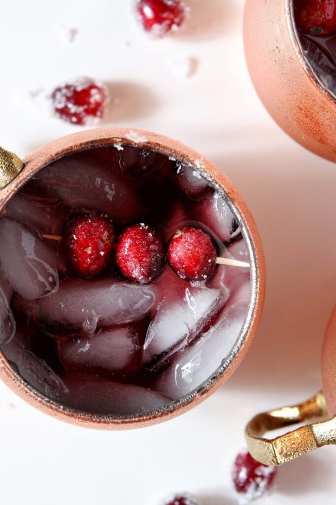 Sugared cranberries sit atop a Moscow Mule, from above