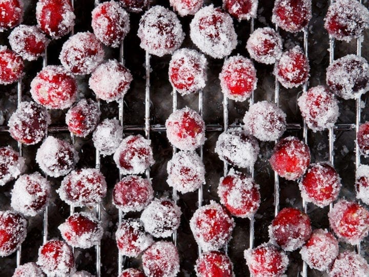 Sugared cranberries sit on a cooling rack, after chilling in the fridge