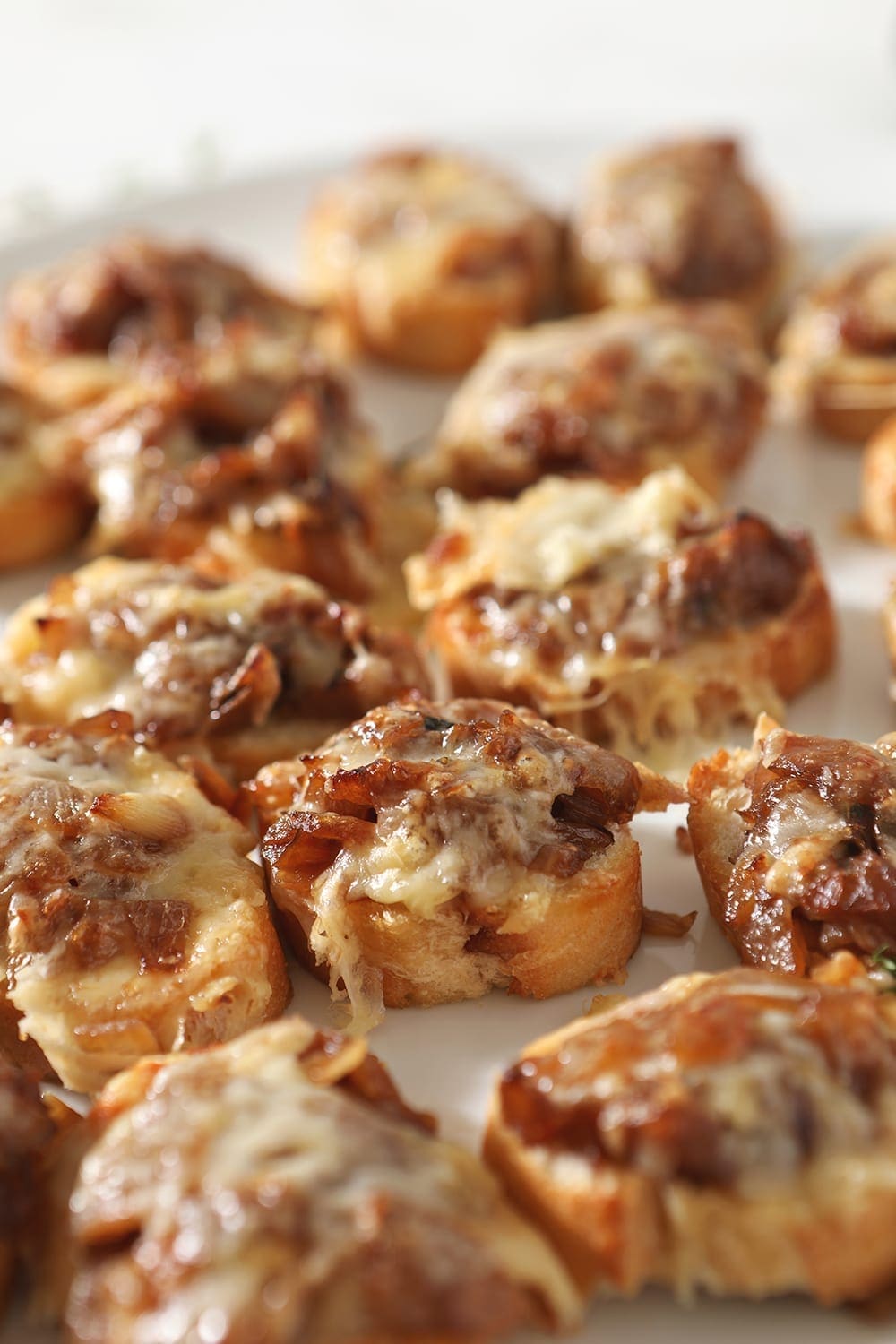 Broiled bruschetta are shown on a baking sheet, before steak slices are added