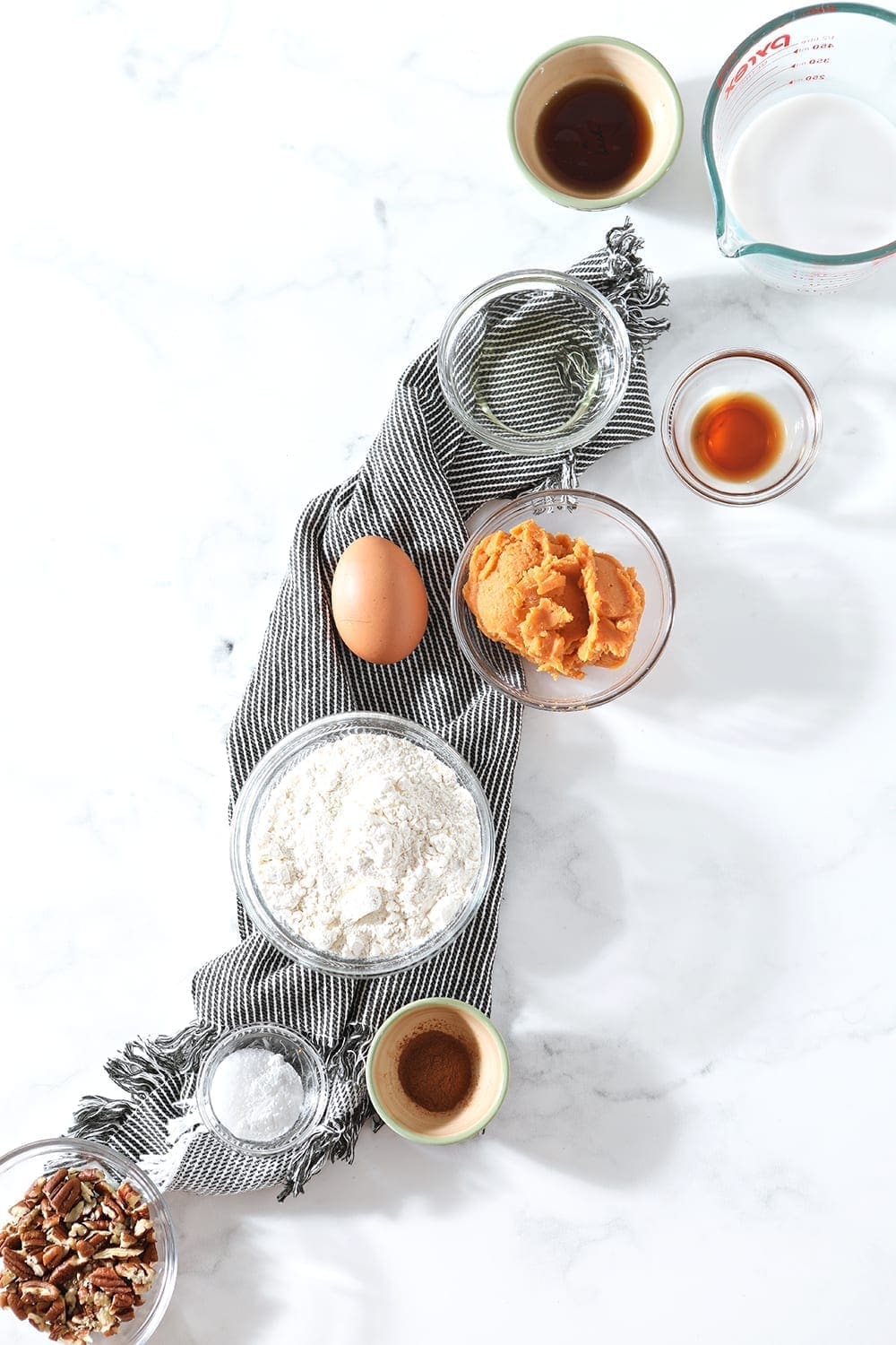 Pancake ingredients are laid out on a blue striped towel, from above