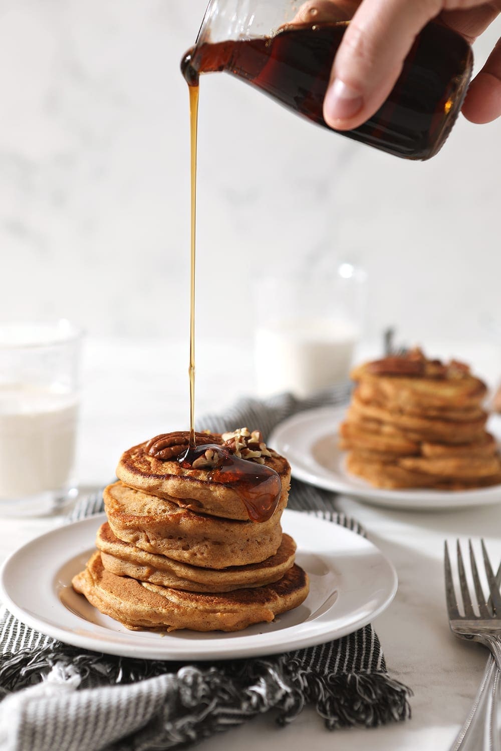 Maple syrup is drizzled onto a stack of Sweet Potato Pancakes