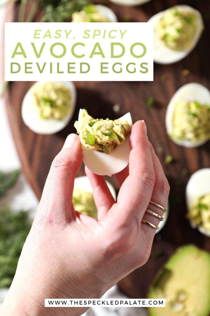 Overhead of a woman holding a deviled egg over a platter with Pinterest text