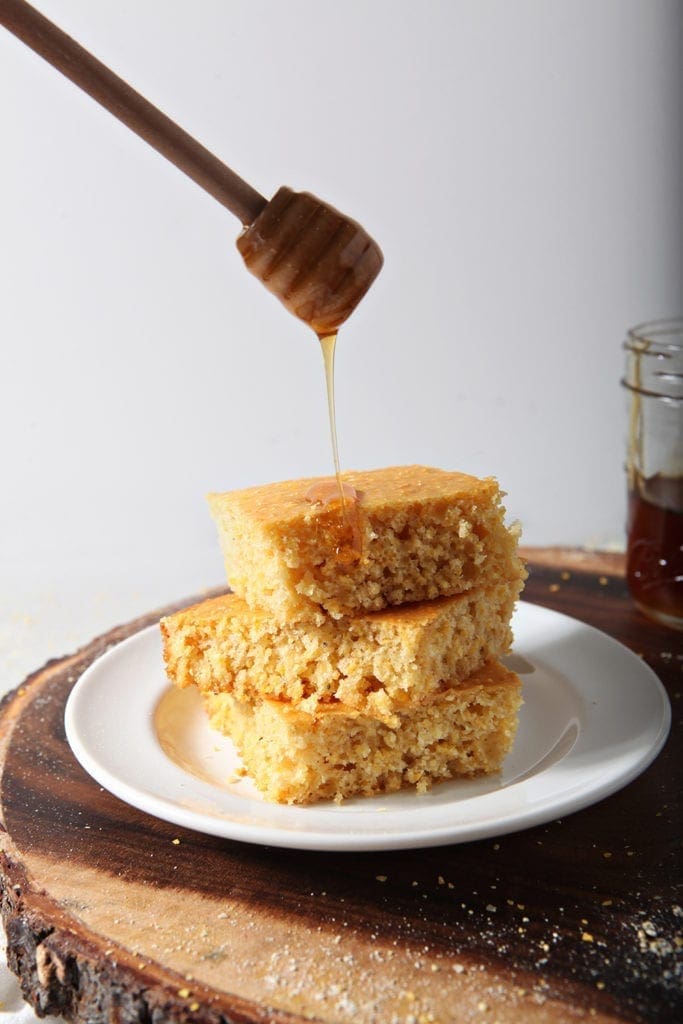 Honey drizzles on top of stacked, sliced cornbread