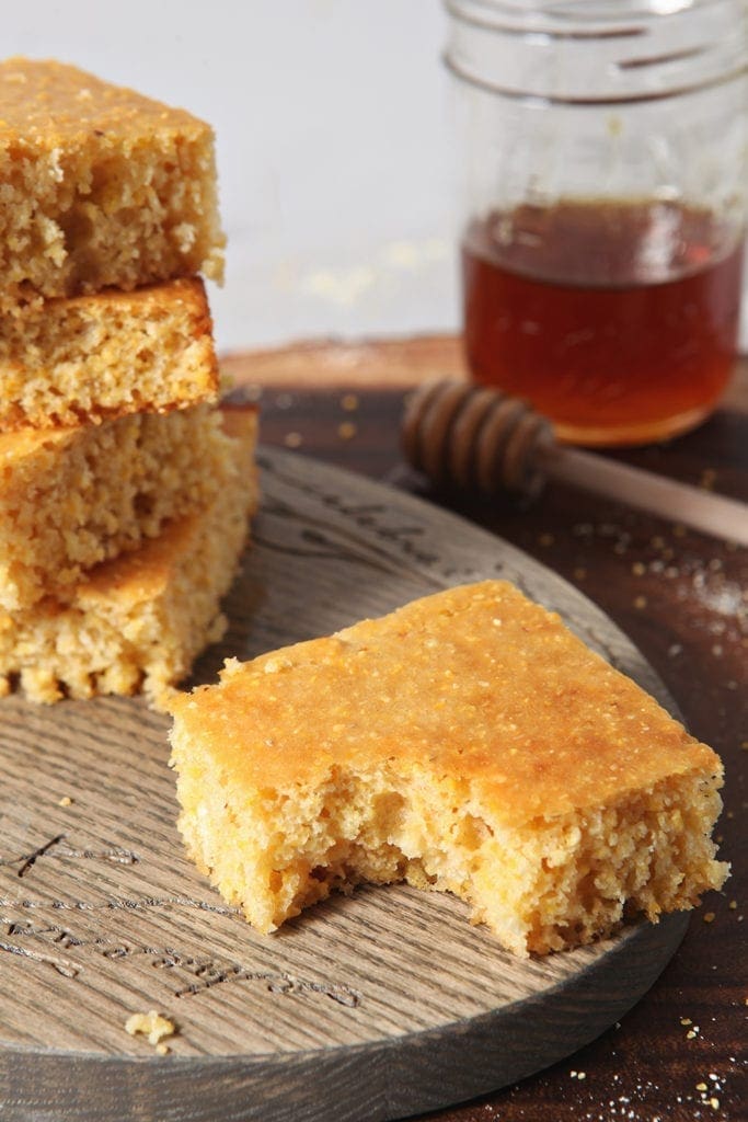 A piece of Honey Cornbread, with other slices, has a bite taken out of it