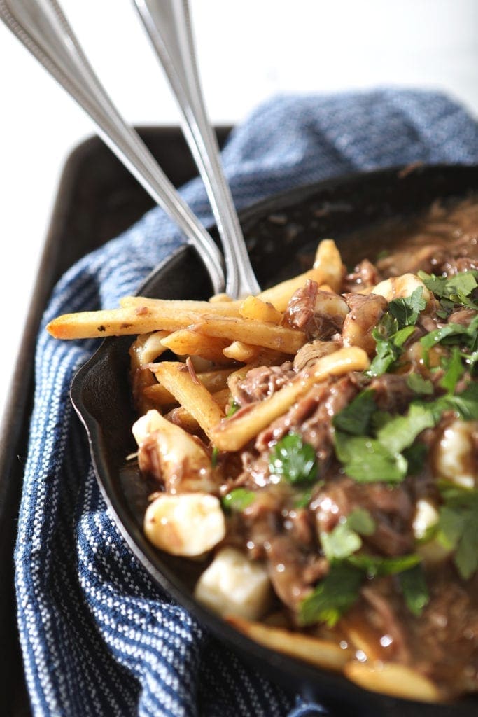 Beefy Poutine Fries and Gravy with forks in a skillet