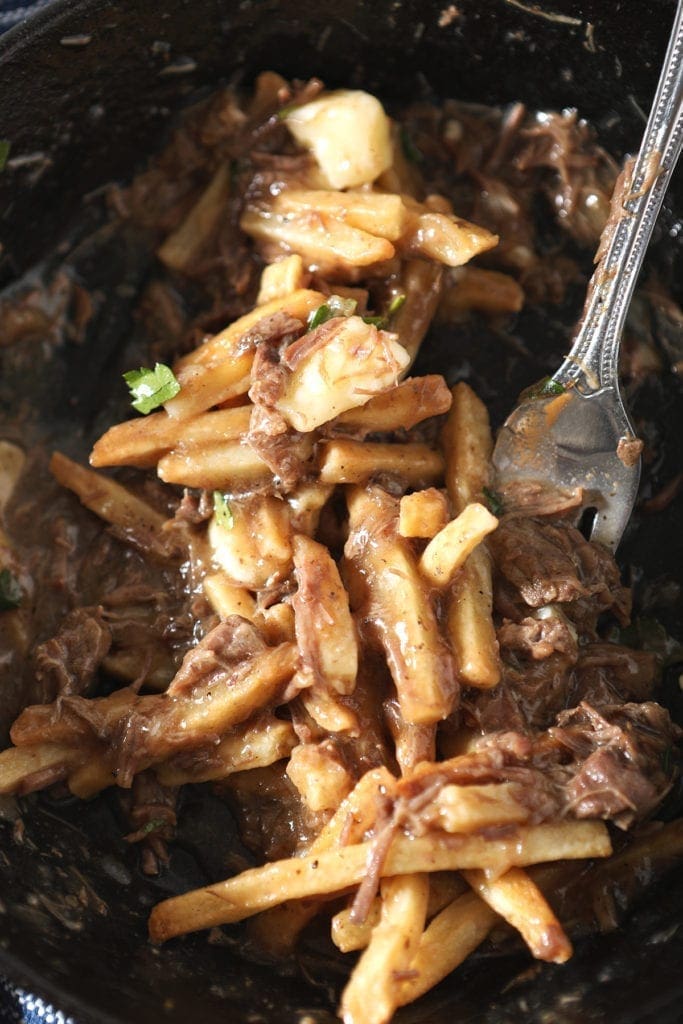 A fork in a bowl of Canadian poutine