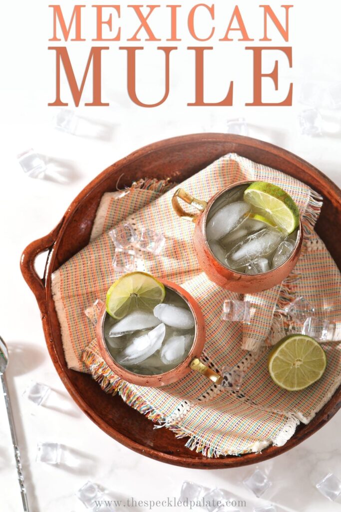 Overhead of two Moscow Mules on a brown platter, with Pinterest text