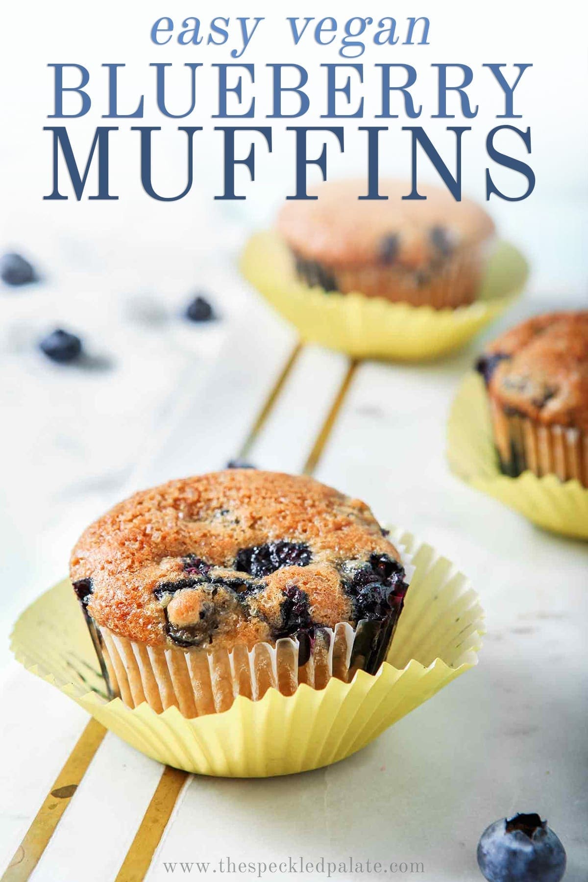 Three Vegan Blueberry Muffins on a marble slab, with Pinterest text