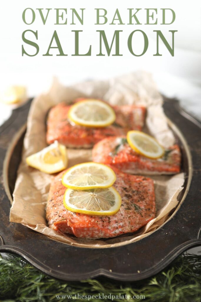 Baked salmon on a silver platter with lemon rounds and fresh dill with Pinterest text stating, "Oven Baked Salmon"