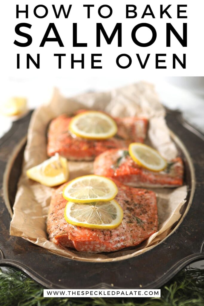 Baked salmon garnished with lemon rounds on parchment paper on a silver platter with Pinterest text stating, "How to Bake Salmon in the Oven"