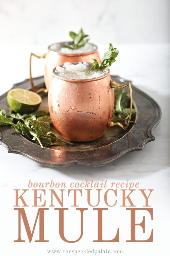 A silver platter holds two copper mugs holding Kentucky Bourbon Mules, with Pinterest text