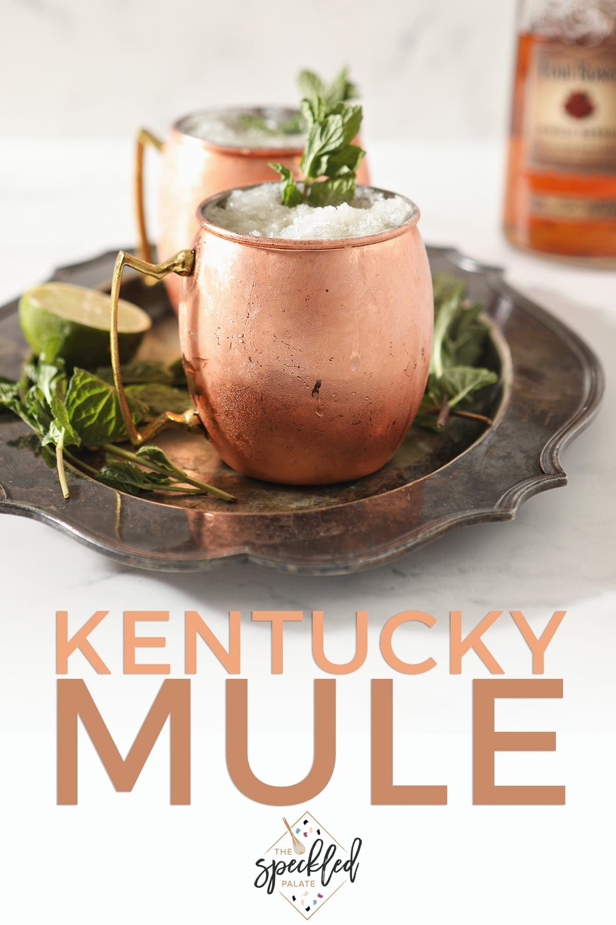 A silver platter holds two copper mugs holding Kentucky Bourbon Mules, with Pinterest text