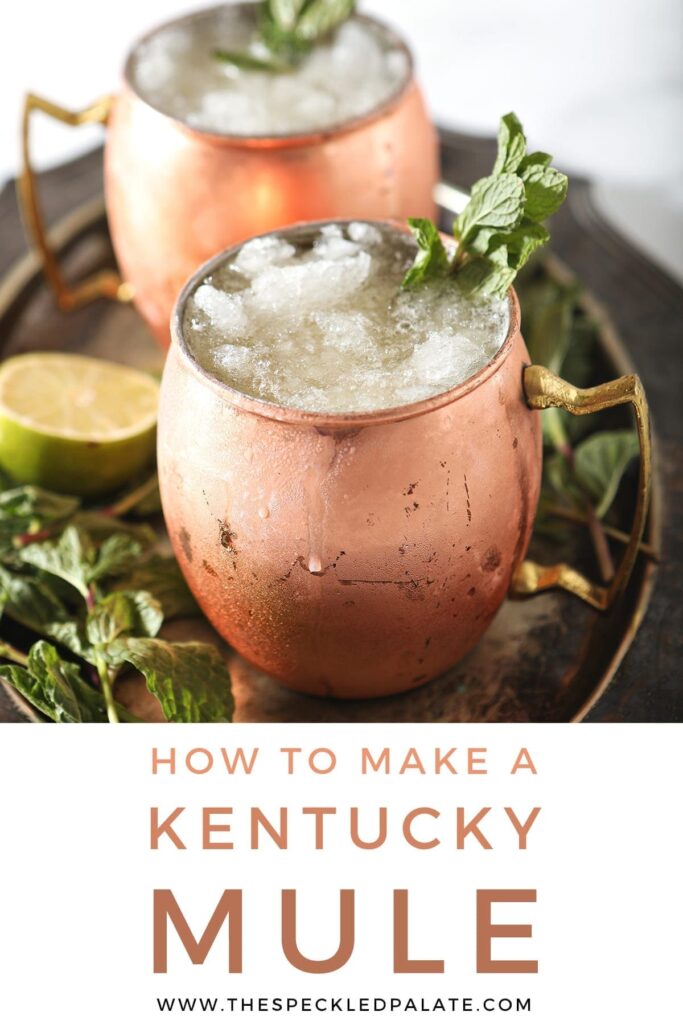 A silver platter holds two copper mugs holding Kentucky Bourbon Mules, with Pinterest text