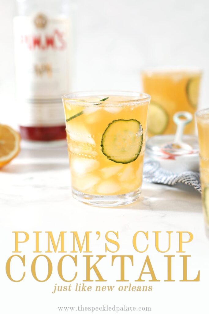 A Pimm's Cup, surrounded by ice and ingredients, is served on a marble surface, with Pinterest text