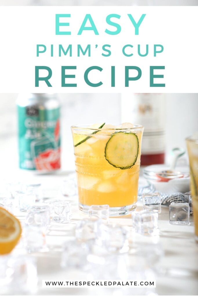 A Pimm's Cup, surrounded by ice and ingredients, is served on a marble surface, with Pinterest text